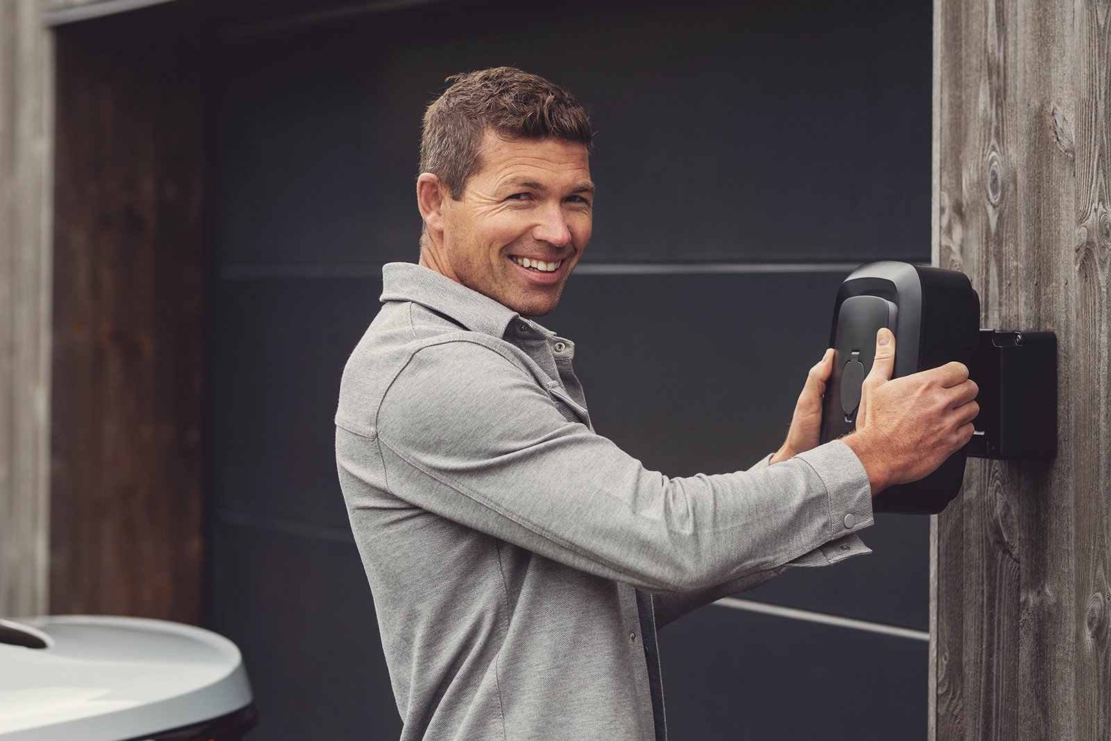 En person, der klikker en Enua Charge fast på den vægmonterede Wallmount